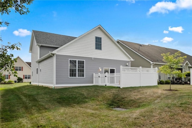 rear view of property featuring a lawn