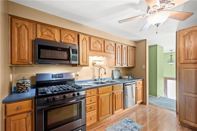 kitchen with sink, light hardwood / wood-style flooring, stainless steel appliances, and ceiling fan