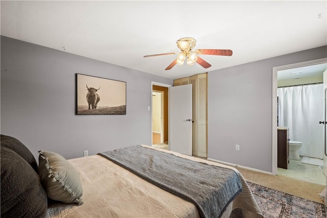 carpeted bedroom with ceiling fan and ensuite bath