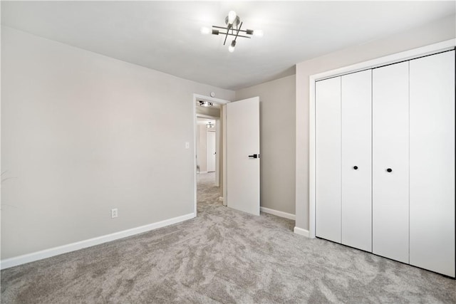 unfurnished bedroom featuring light colored carpet and a closet