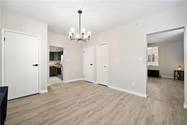 unfurnished dining area featuring an inviting chandelier, radiator heating unit, and light hardwood / wood-style floors