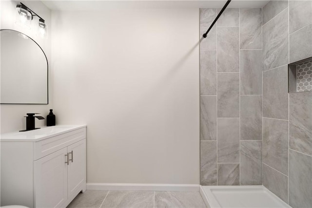 bathroom with vanity and tiled shower