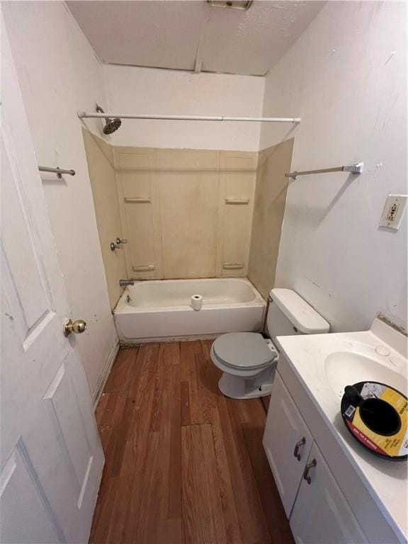 full bathroom featuring vanity, hardwood / wood-style flooring, tub / shower combination, and toilet