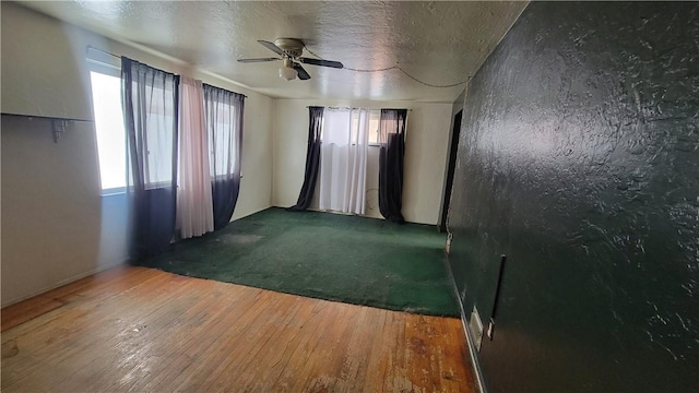 spare room featuring ceiling fan, hardwood / wood-style floors, and a textured ceiling