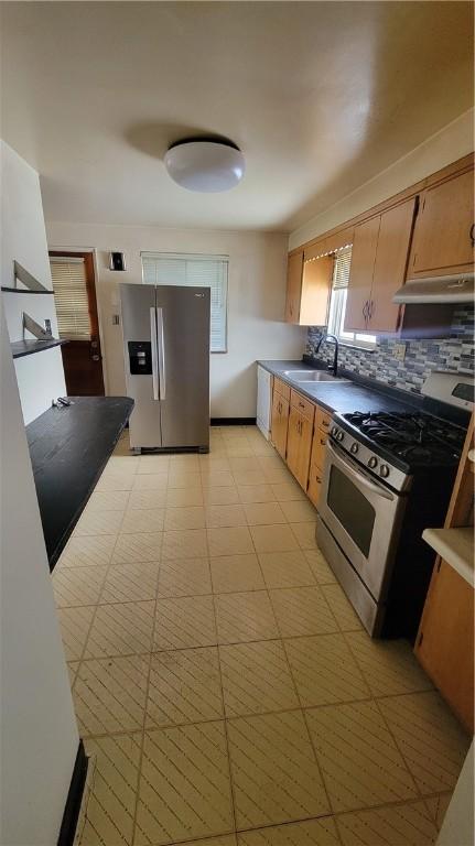 kitchen featuring stainless steel appliances, sink, and decorative backsplash