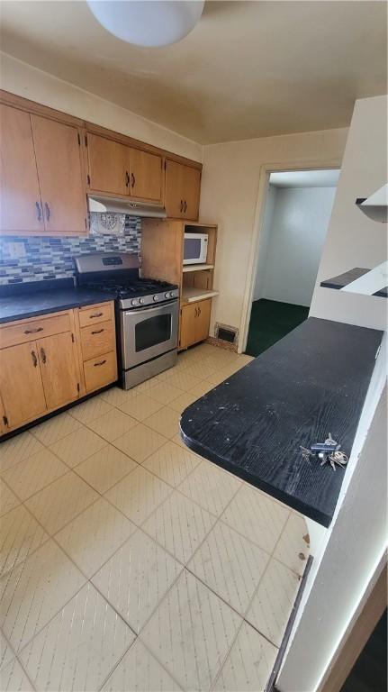 kitchen featuring backsplash and gas range