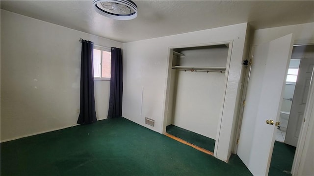 unfurnished bedroom featuring a closet and dark colored carpet