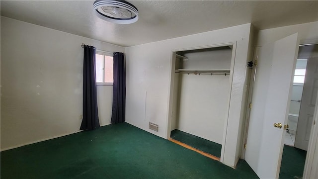 unfurnished bedroom with a closet and dark colored carpet