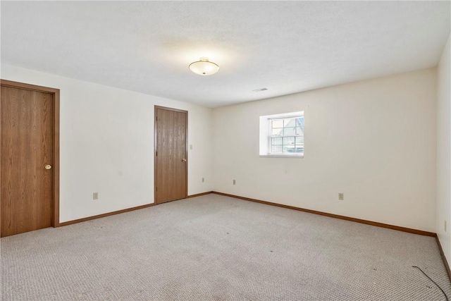 unfurnished room featuring light carpet