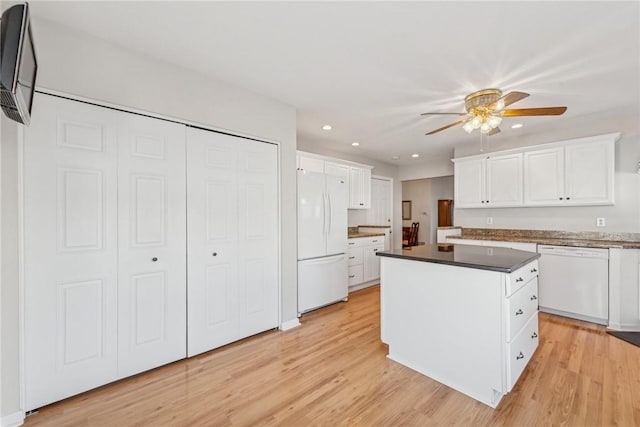 kitchen with white cabinets, a center island, ceiling fan, light hardwood / wood-style floors, and white appliances