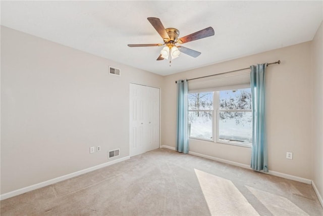 spare room with light colored carpet and ceiling fan