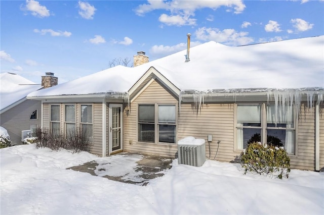 snow covered house with central AC