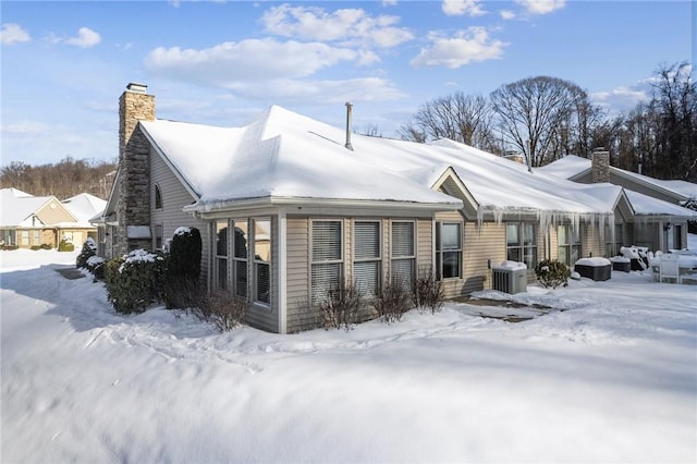 snow covered property featuring central AC unit