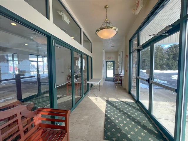 hallway featuring light tile patterned floors, plenty of natural light, and french doors