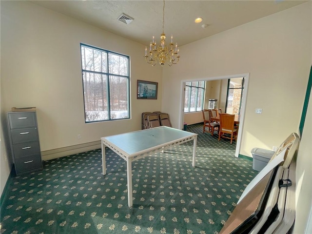 recreation room with plenty of natural light, a chandelier, and dark colored carpet