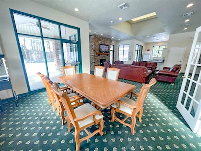 dining space featuring french doors, a fireplace, and carpet floors