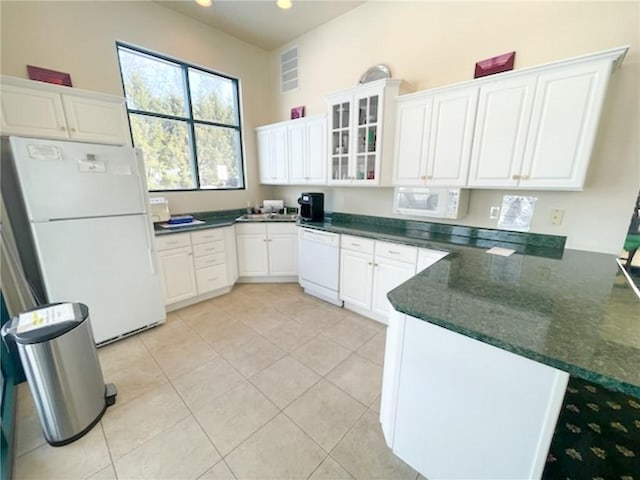 kitchen featuring white appliances, kitchen peninsula, white cabinets, and light tile patterned flooring