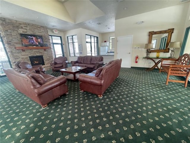 carpeted living room with a stone fireplace