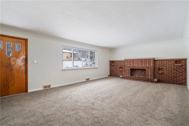 unfurnished living room featuring crown molding, carpet floors, and a fireplace