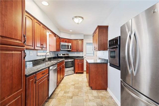 kitchen with dark stone countertops, sink, and appliances with stainless steel finishes