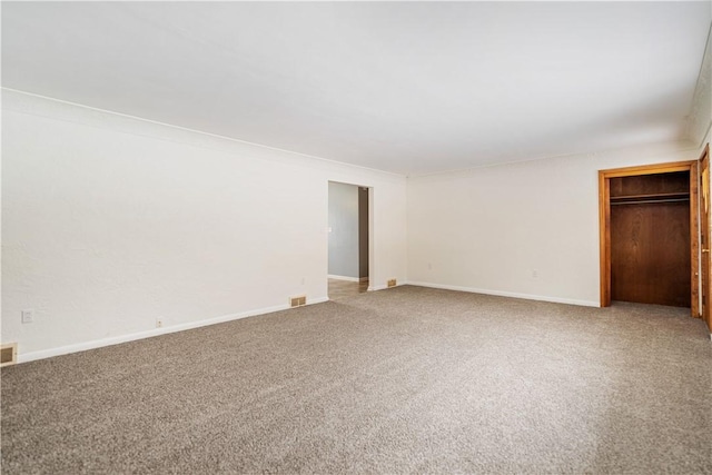 unfurnished bedroom with ornamental molding, carpet floors, and a closet