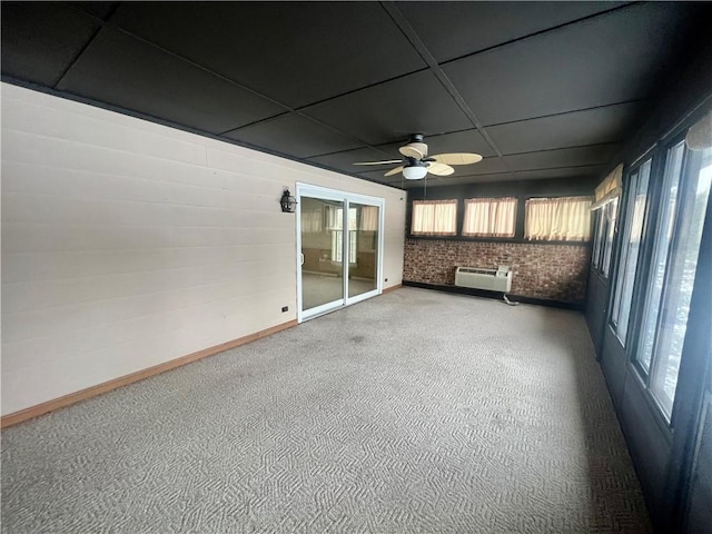 unfurnished sunroom featuring a wall mounted AC and ceiling fan