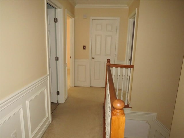 corridor featuring ornamental molding and light carpet