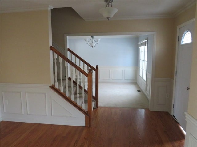 foyer entrance with crown molding and dark hardwood / wood-style floors