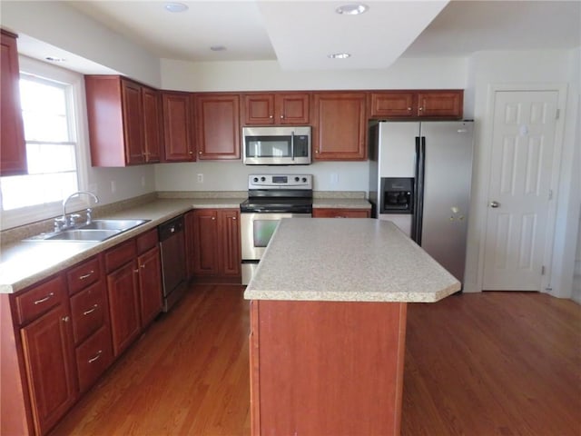 kitchen featuring dark hardwood / wood-style flooring, sink, stainless steel appliances, and a kitchen island