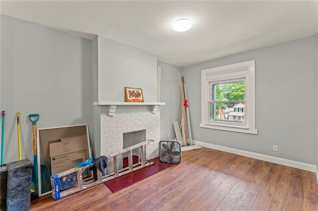 living room featuring a brick fireplace and hardwood / wood-style floors