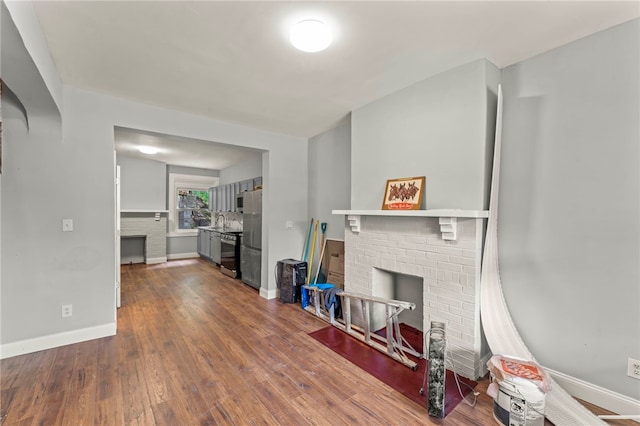 living room with dark hardwood / wood-style floors and a brick fireplace