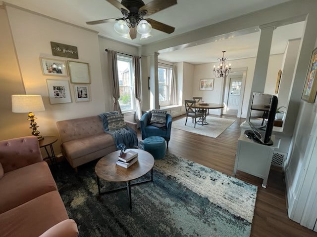 living room featuring ornate columns, dark wood-type flooring, and ceiling fan with notable chandelier