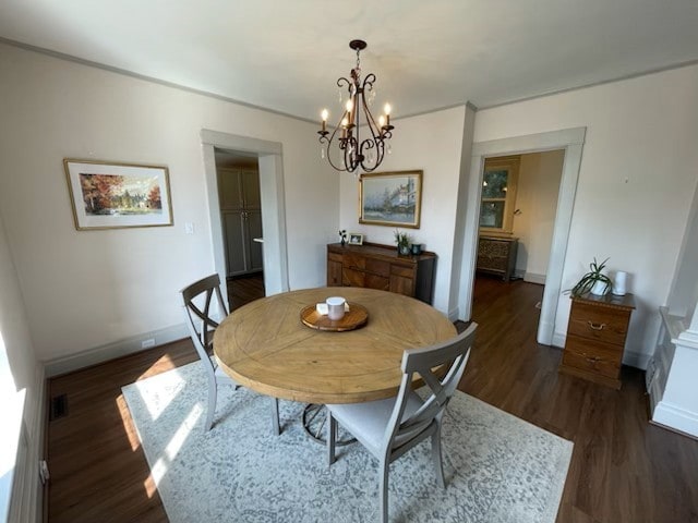 dining room featuring dark hardwood / wood-style flooring and a notable chandelier