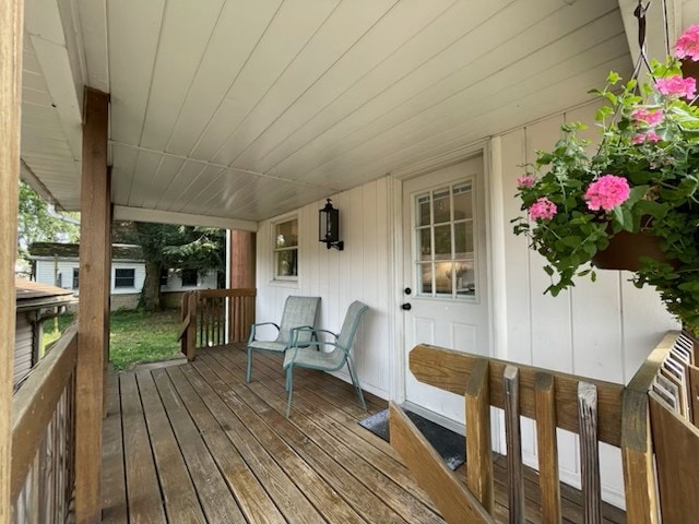 deck with covered porch and a storage shed