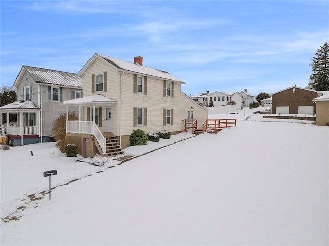 view of snow covered back of property