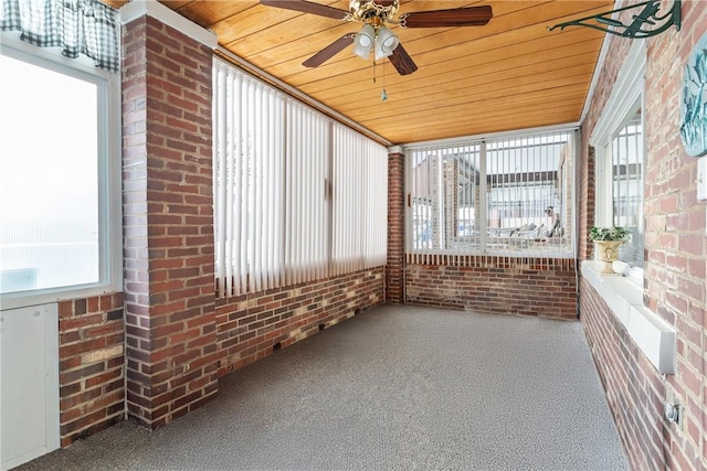 unfurnished sunroom with ceiling fan, a wealth of natural light, and wooden ceiling