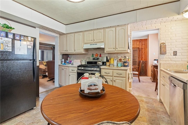 kitchen featuring sink, backsplash, cream cabinets, and appliances with stainless steel finishes