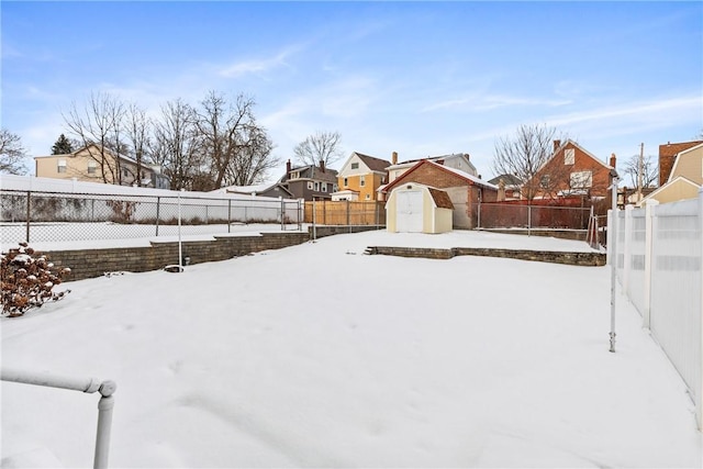 yard covered in snow featuring a storage shed