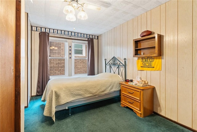 carpeted bedroom with ceiling fan and wood walls