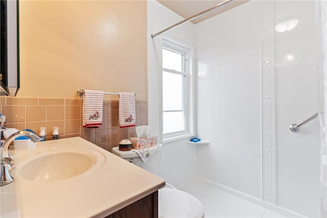 bathroom featuring vanity, a shower with shower curtain, tile walls, and toilet