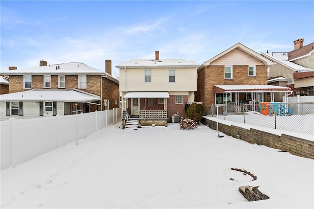 snow covered back of property featuring central AC and a porch