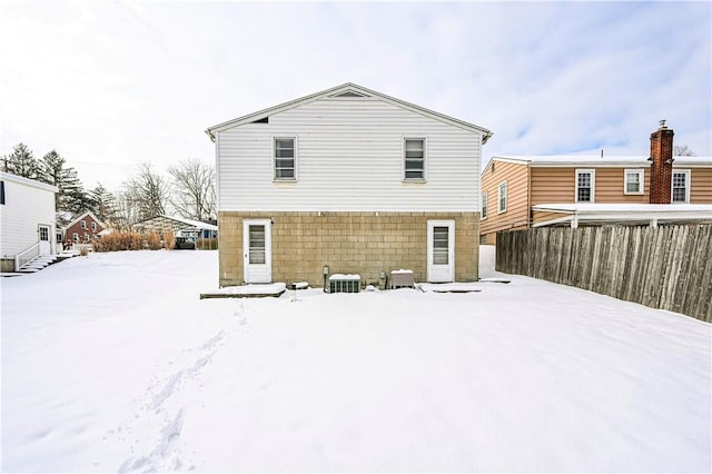 snow covered back of property with central AC unit