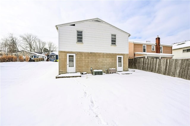 snow covered back of property with cooling unit