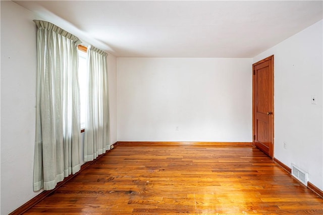 unfurnished room with hardwood / wood-style flooring