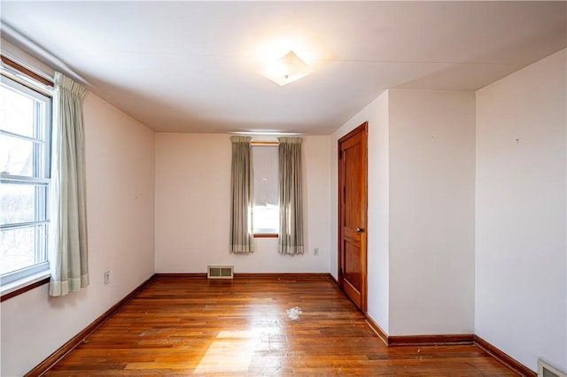 unfurnished room with a wealth of natural light and wood-type flooring