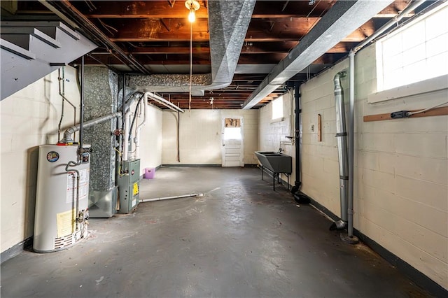 basement with gas water heater, a healthy amount of sunlight, and sink