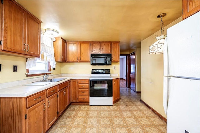 kitchen with white refrigerator, hanging light fixtures, electric range oven, and sink