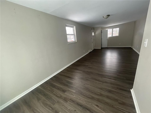 spare room featuring dark wood-type flooring and a healthy amount of sunlight