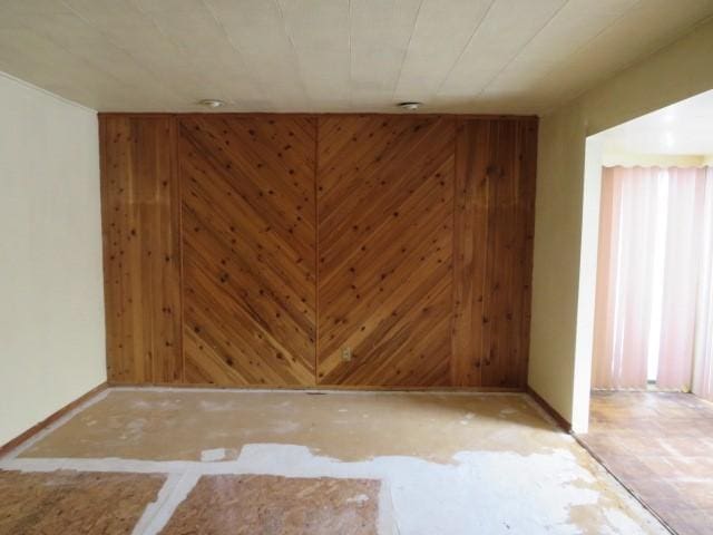 empty room featuring wood walls