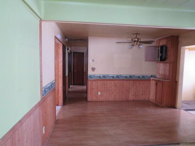 hall featuring light hardwood / wood-style flooring and wood walls